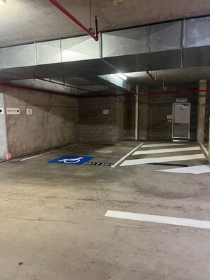 Eine Parkgarage mit Rezeption, Aufzug und Behindertenparkplatz.