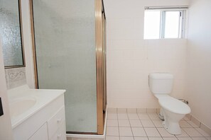 A bathroom with a shower, toilet, and sink. - 1 Bed Apartment on Henry (West End)
