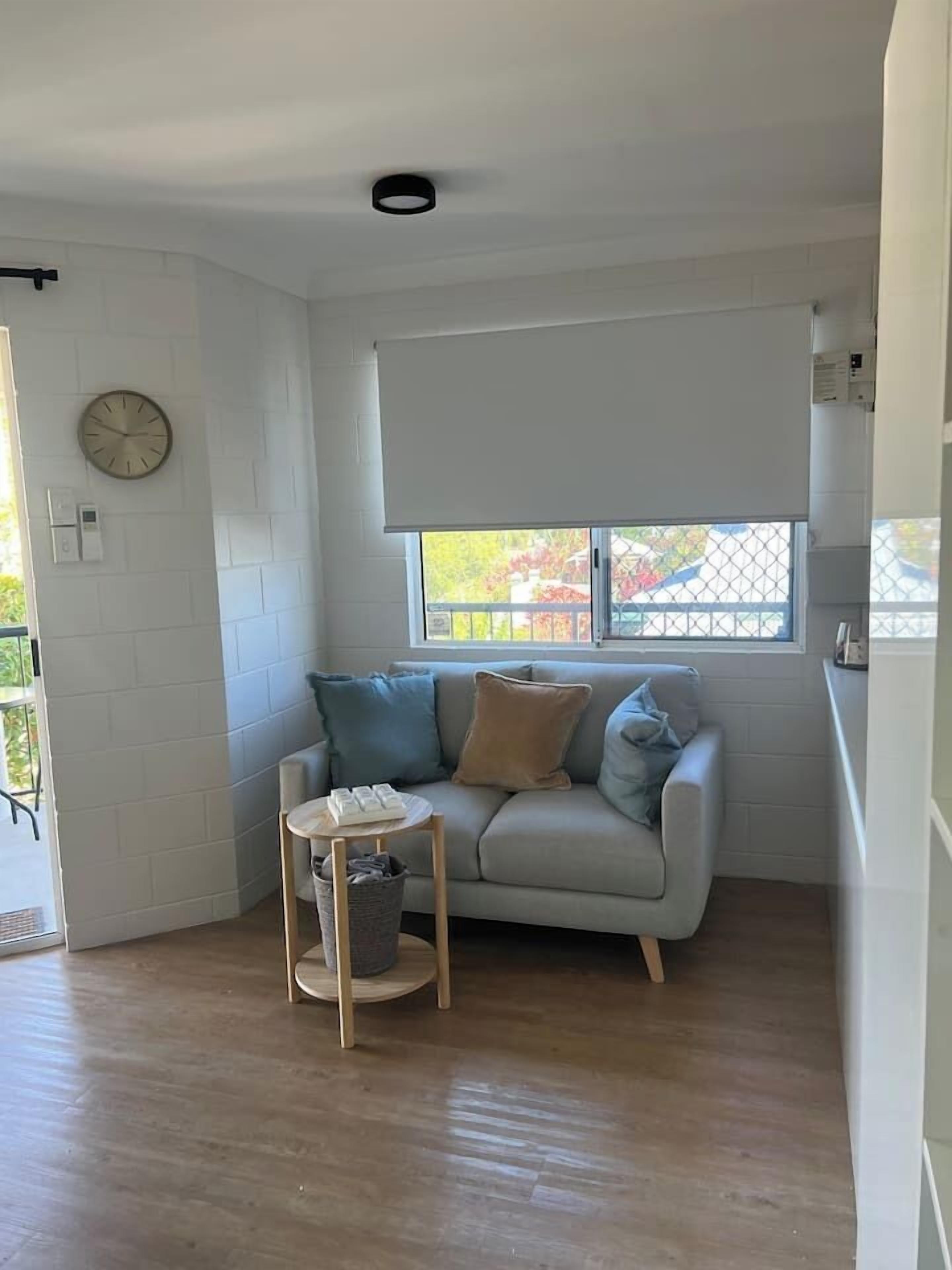 A room with a sofa, a small table, and a window with a view.