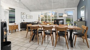 A spacious kitchen with a dining area, wooden furniture, and large windows. - Super nice holiday home with whirlpool (Højslev)