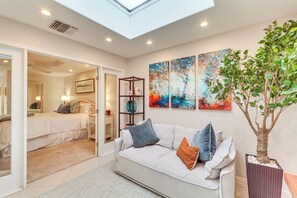 Una sala moderna con un sofá, una mesa de centro y un ventanal grande.