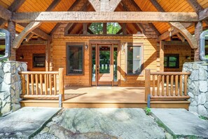 A wooden cabin with a porch, stone walls, and a wooden deck. - Game Room + Deck: Spacious Spruce Pine Retreat! (Spruce Pine)