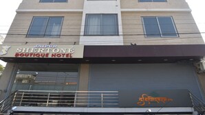 Un immeuble à plusieurs étages, sur lequel on peut voir une enseigne indiquant le « Jaipur Sherzone Boutique Hotel ».