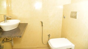 Une salle de bain avec un lavabo blanc, une douche et des toilettes.
