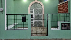 A gated entrance with a metal gate, a green wall, and a number '590' on the wall. - Merida Centro House with Private Pool and Air Conditioning (Mérida)
