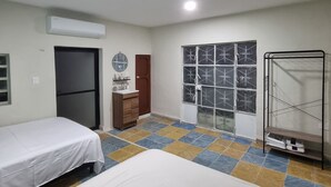 A room with two beds, a wardrobe, a window with frosted glass, and an air conditioning unit. - Merida Centro House with Private Pool and Air Conditioning (Mérida)