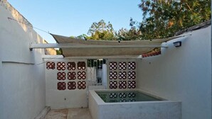A small, enclosed outdoor space with a concrete pool, tiled walls, and a pergola. - Merida Centro House with Private Pool and Air Conditioning (Mérida)