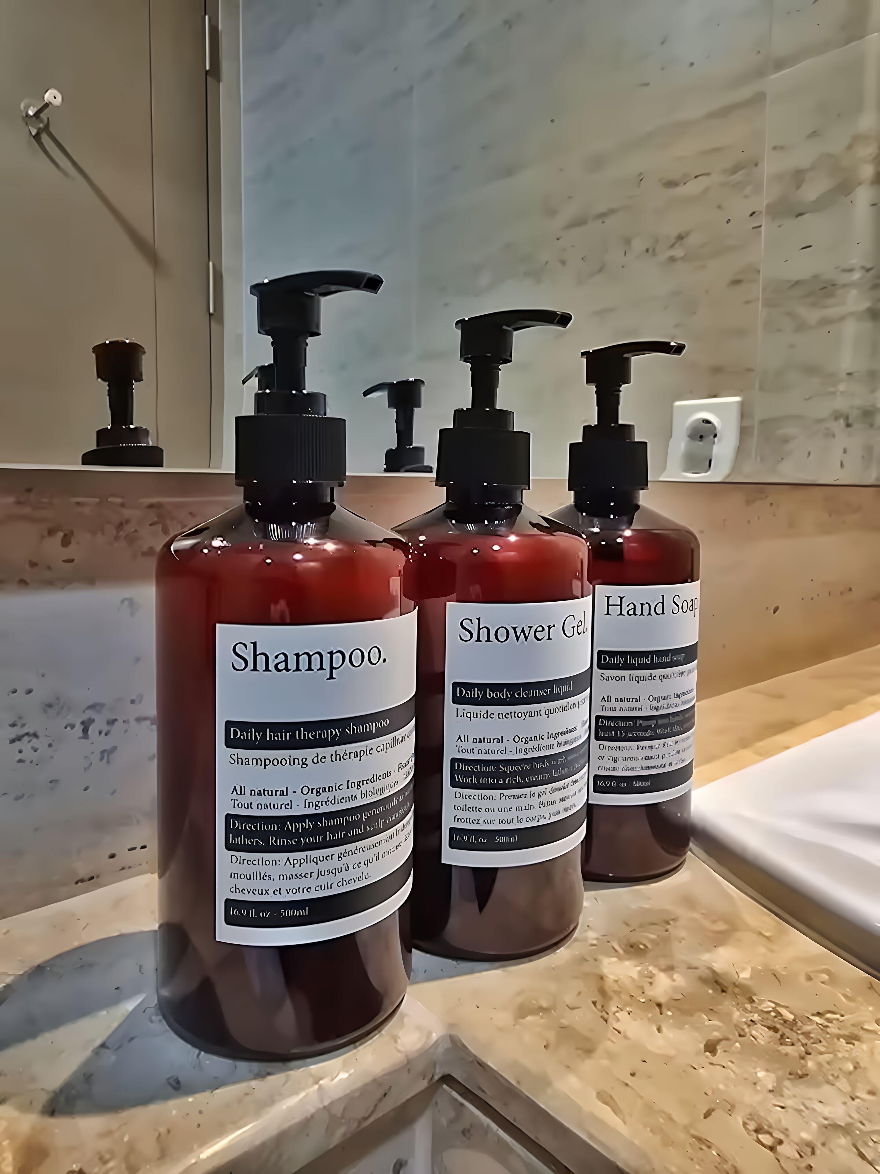 Three bottles of shampoo and shower gel on a bathroom counter.