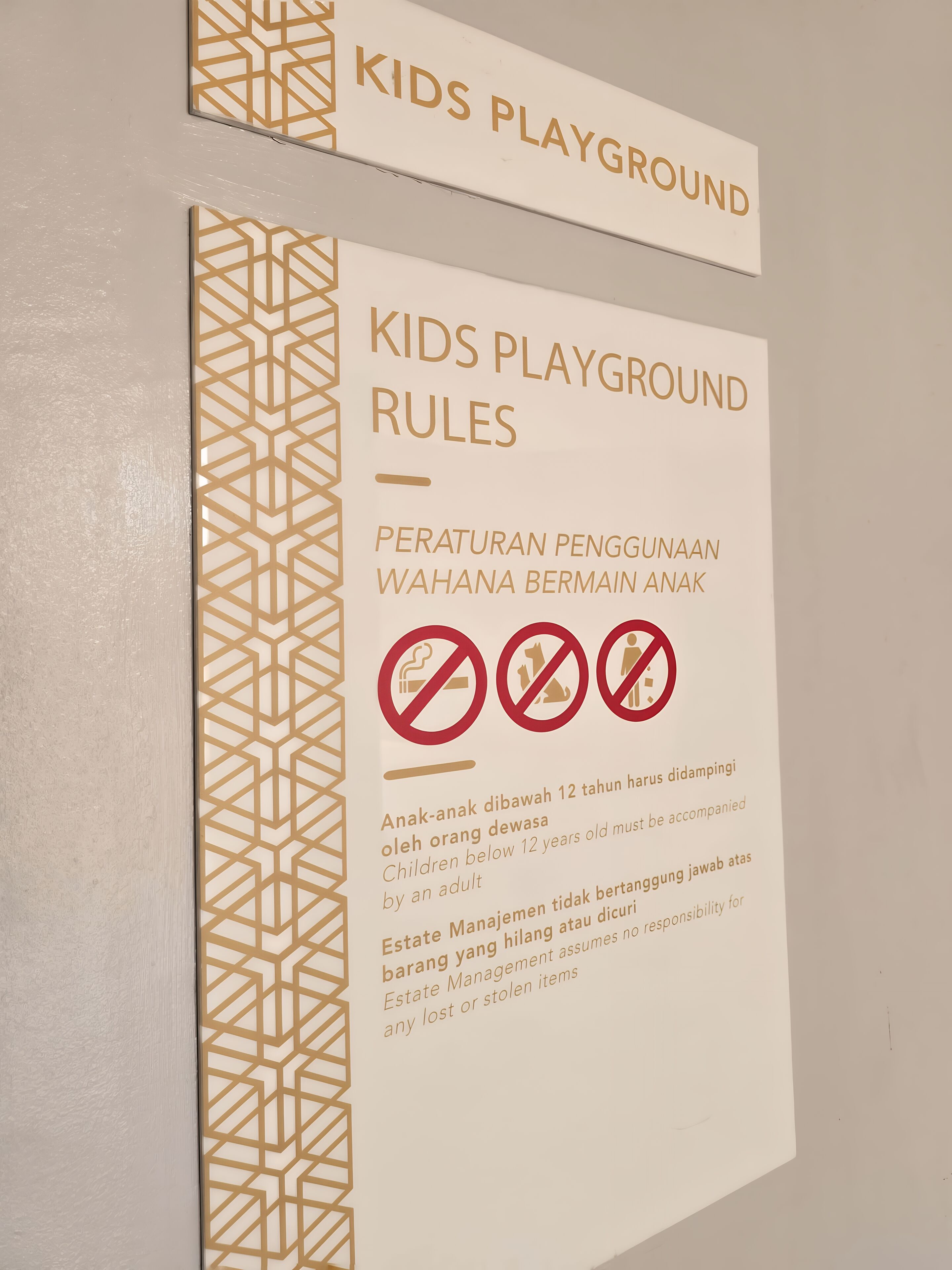 Señal con normas del parque infantil, incluyendo restricciones de edad y prohibiciones.