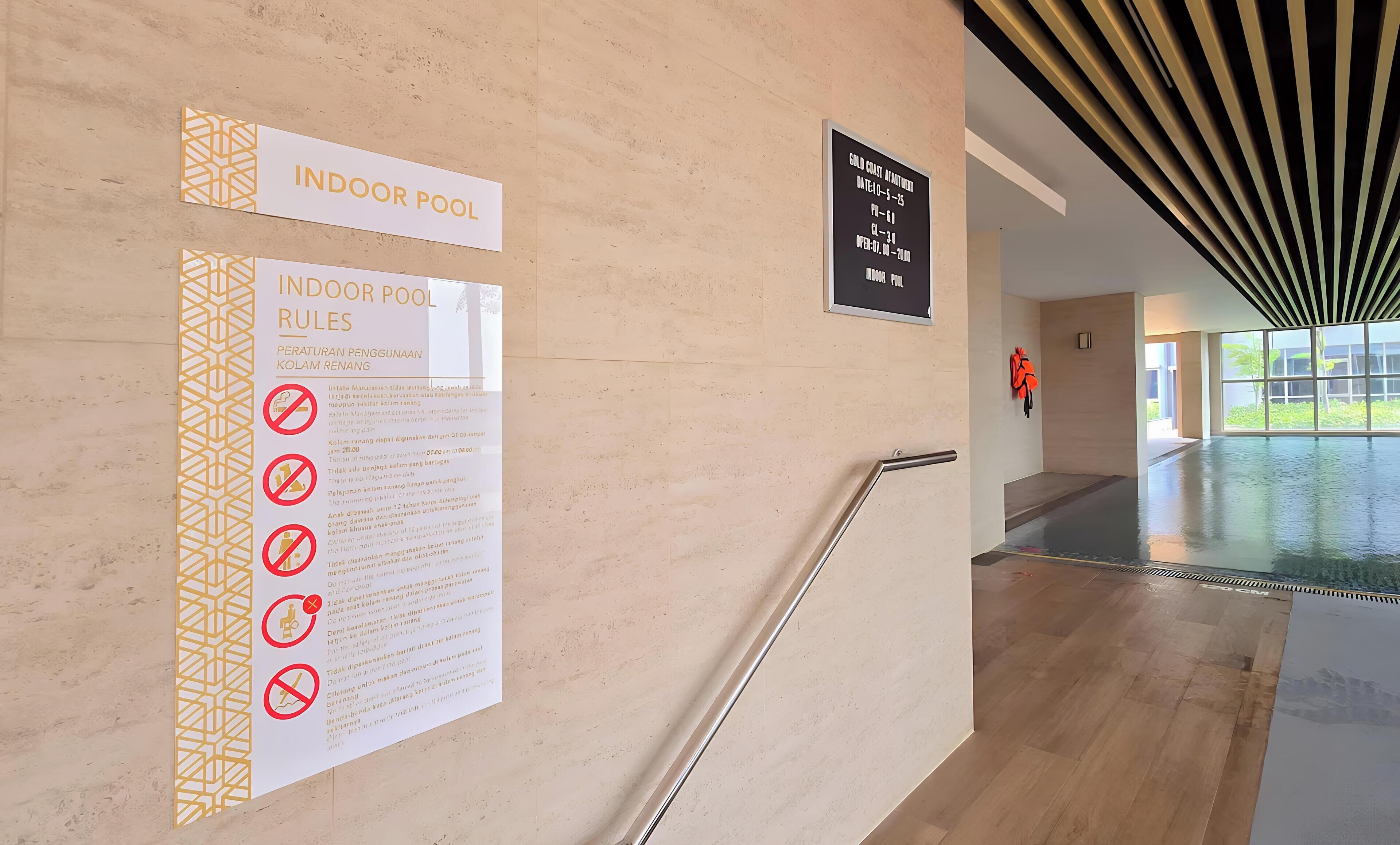 Un couloir mène à une piscine intérieure, et une pancarte indique les règles de la piscine ainsi qu’un programme des activités liées aux pièces d’or.