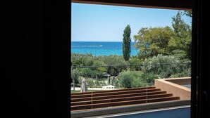 Un balcon avec vue sur la mer et la verdure.