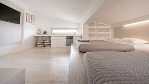 Un dormitorio con dos camas, un escritorio y una ventana.