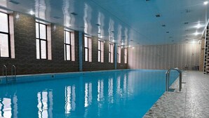 An indoor swimming pool with clear water, tiled walls, and a tiled floor. - Imperial Hotel (Kapan)