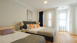 Une chambre d’hôtel avec deux lits, une table de chevet, une lampe et un tableau au mur.