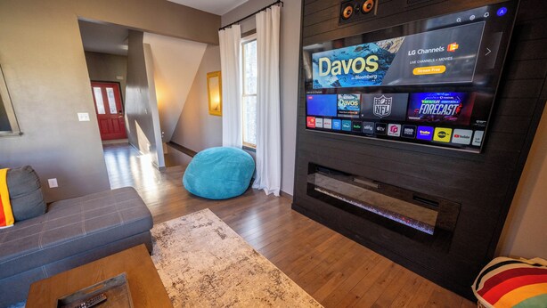 A modern living room with a flat-screen TV displaying various streaming services, a grey sofa, a blue bean bag, and a wooden coffee table. - Family Retreat- Sauna, Arcade, Gym & Message Chair (Helena)