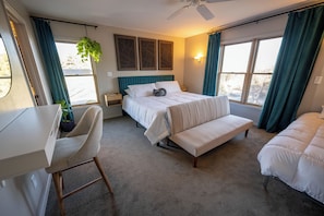 Une chambre à coucher avec un lit, un banc, un bureau et une chaise.