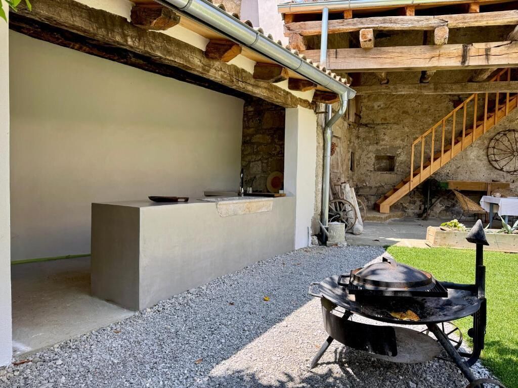Un espace cuisine extérieur équipé d’un barbecue et d’un comptoir en béton.