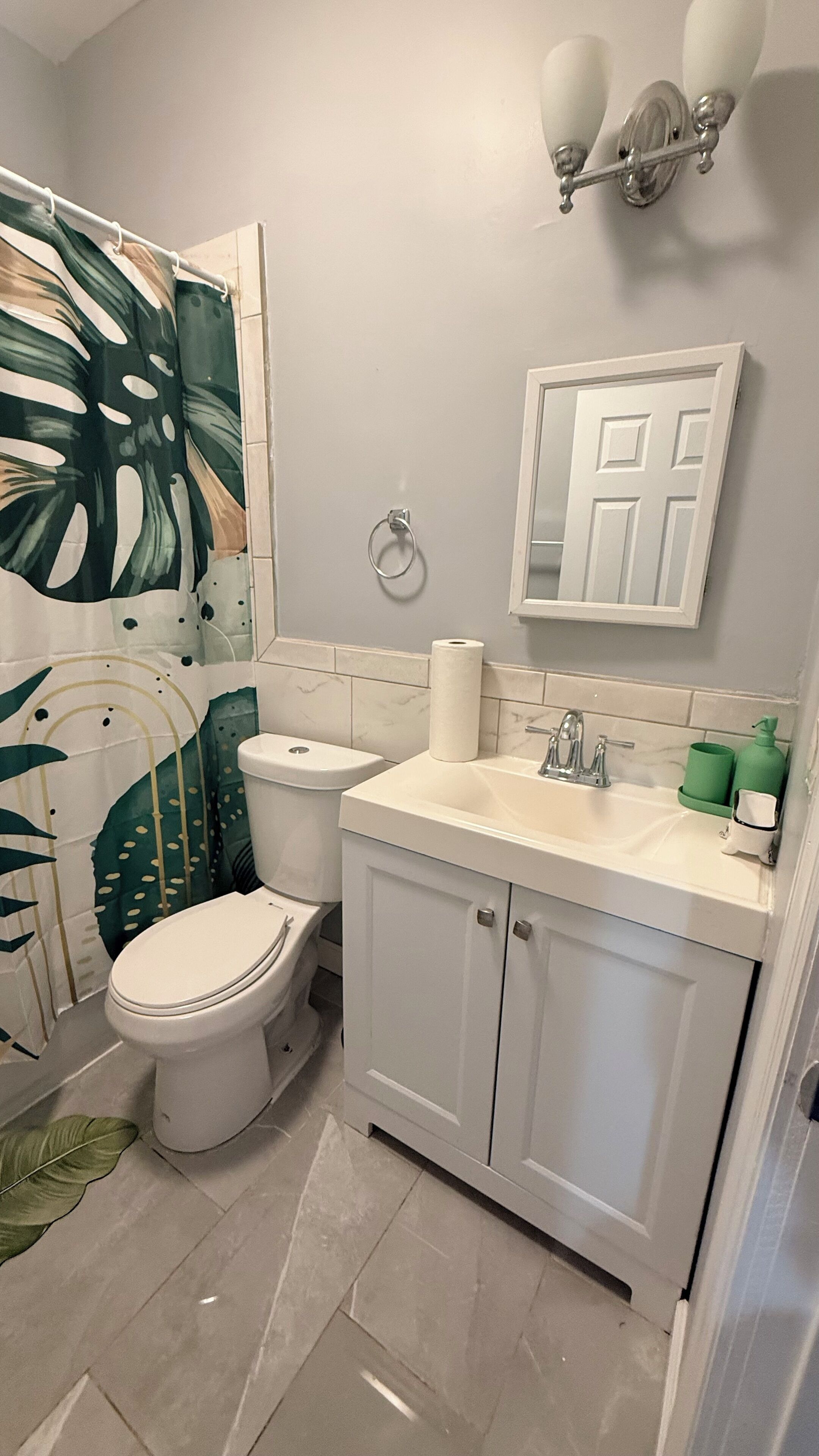 A bathroom with a toilet, sink, and cabinet.