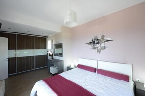 A modern bedroom with a large bed, a wardrobe, a vanity, and a unique wall decoration. - Two floor villa with great view on both sides of the islandand. (ALONNISOS)