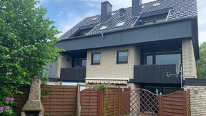 A two-story house with a brick facade, a tiled roof, and a stone-built outdoor oven. - Apartment "Halvar" with Balcony and WiFi (Maasholm)