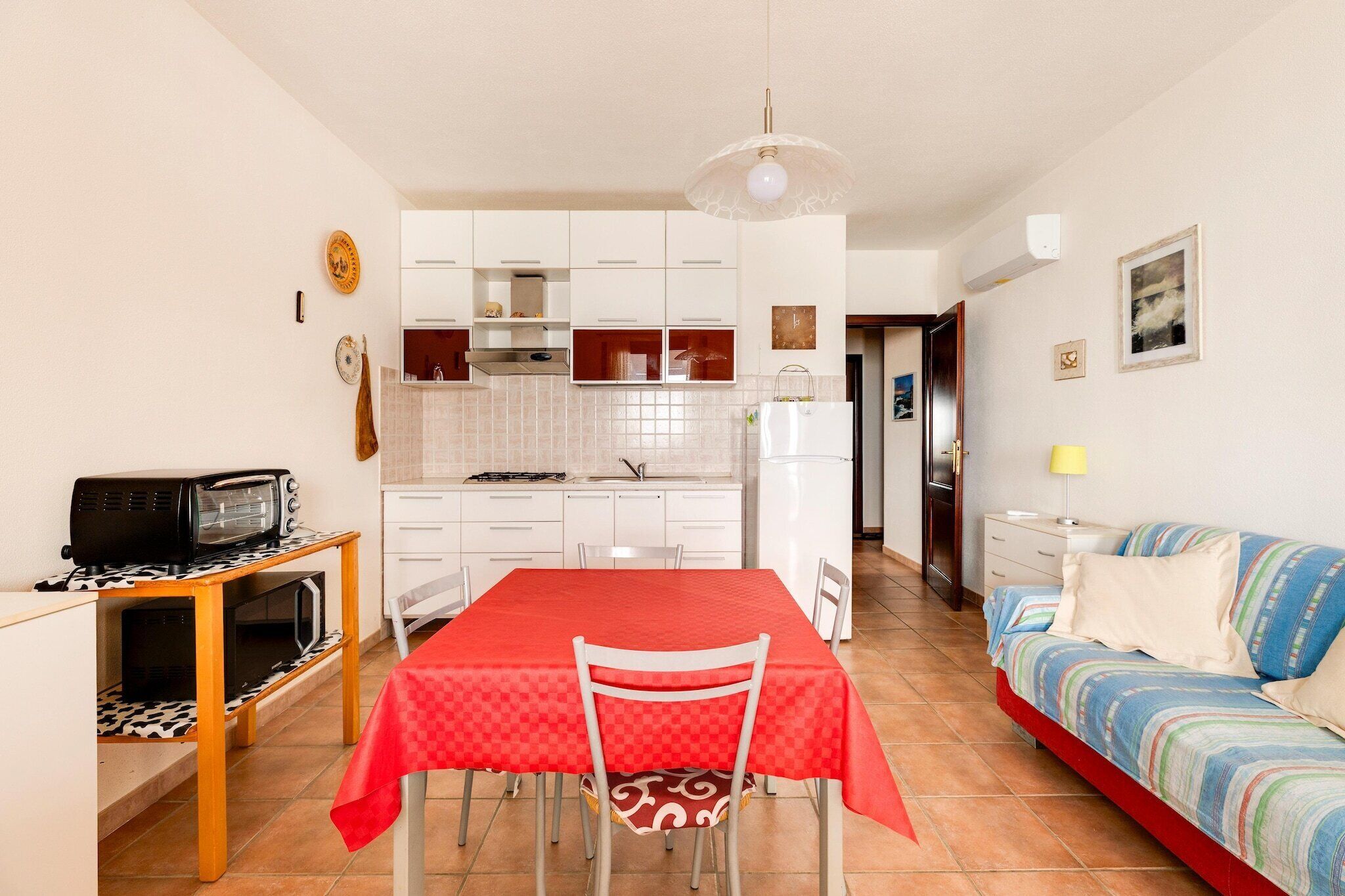 A compact living space with a kitchenette, dining area, and a sofa.