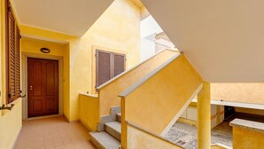 A corridor leading to a staircase with a door and window. - With beachfront terrace and air conditioning (Castelsardo)