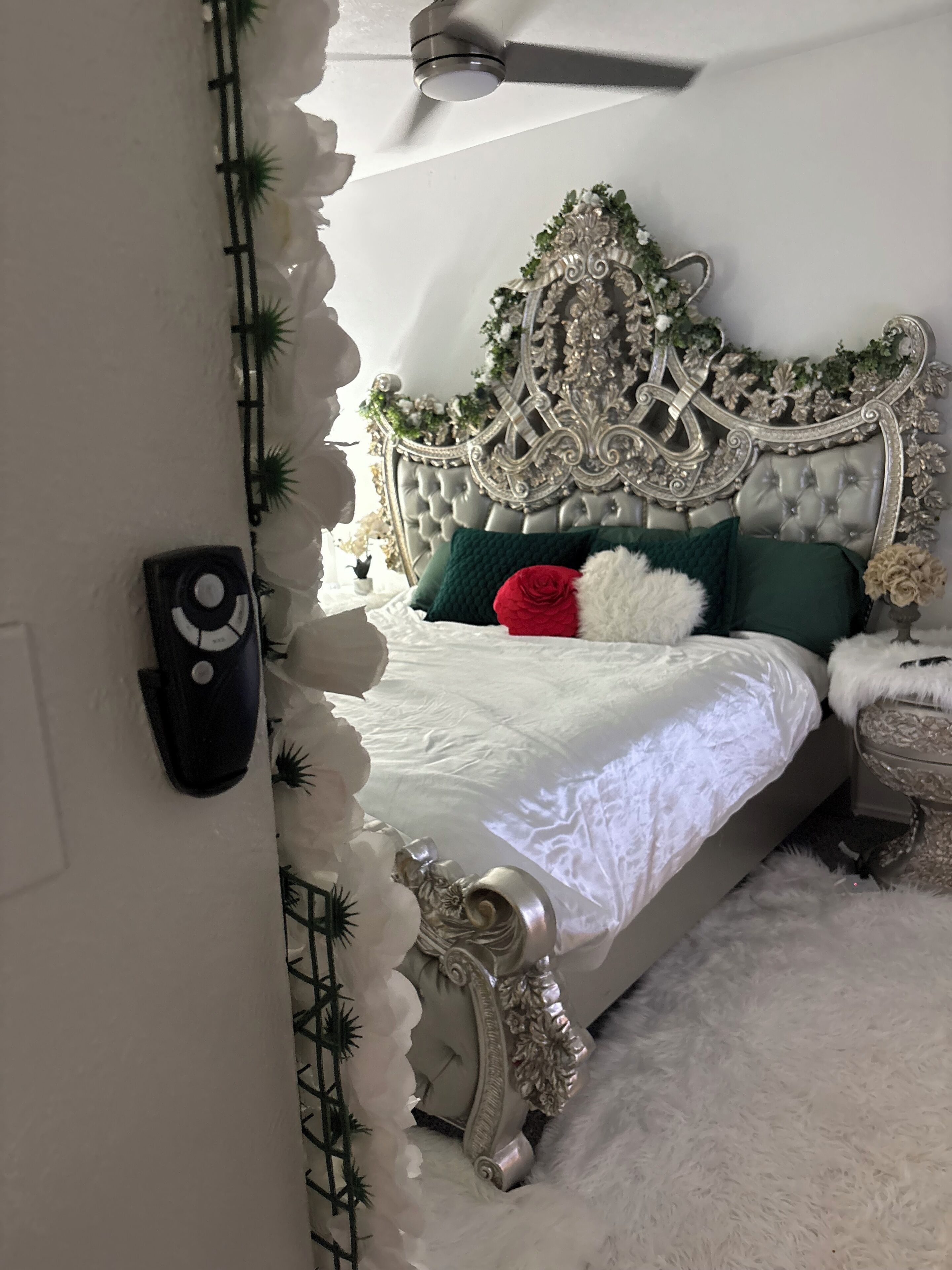 A bedroom with a tufted headboard, white bedding, and decorative pillows.