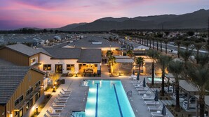 A swimming pool with lounge chairs, a poolside area, and a view of mountains in the background. - Sleeps 20 | Two 4BR Homes | Resort Pool + Hot Tub + Firepit | Summerwell (Thermal)