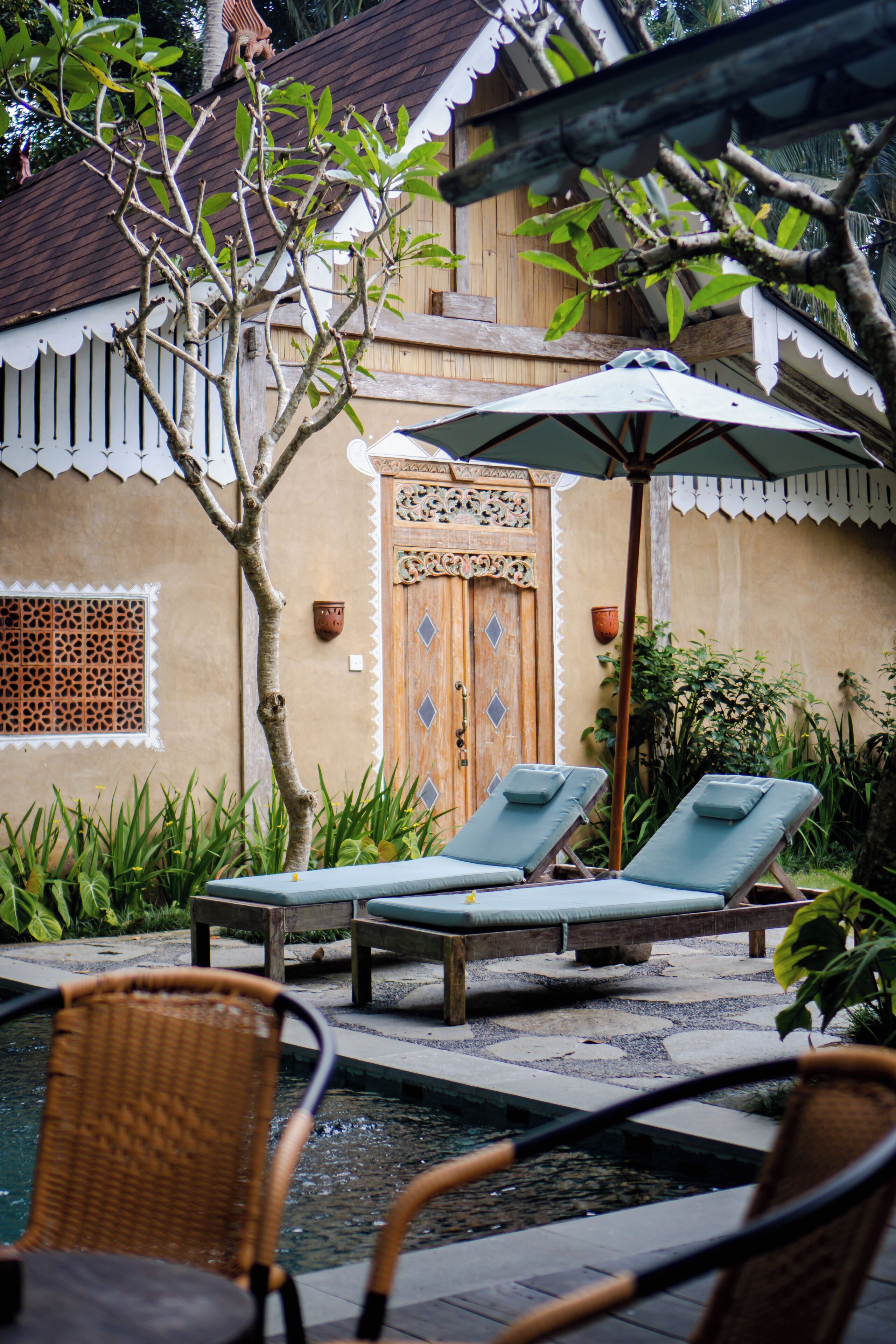 A poolside area with lounge chairs, a small pool, and a decorative door.