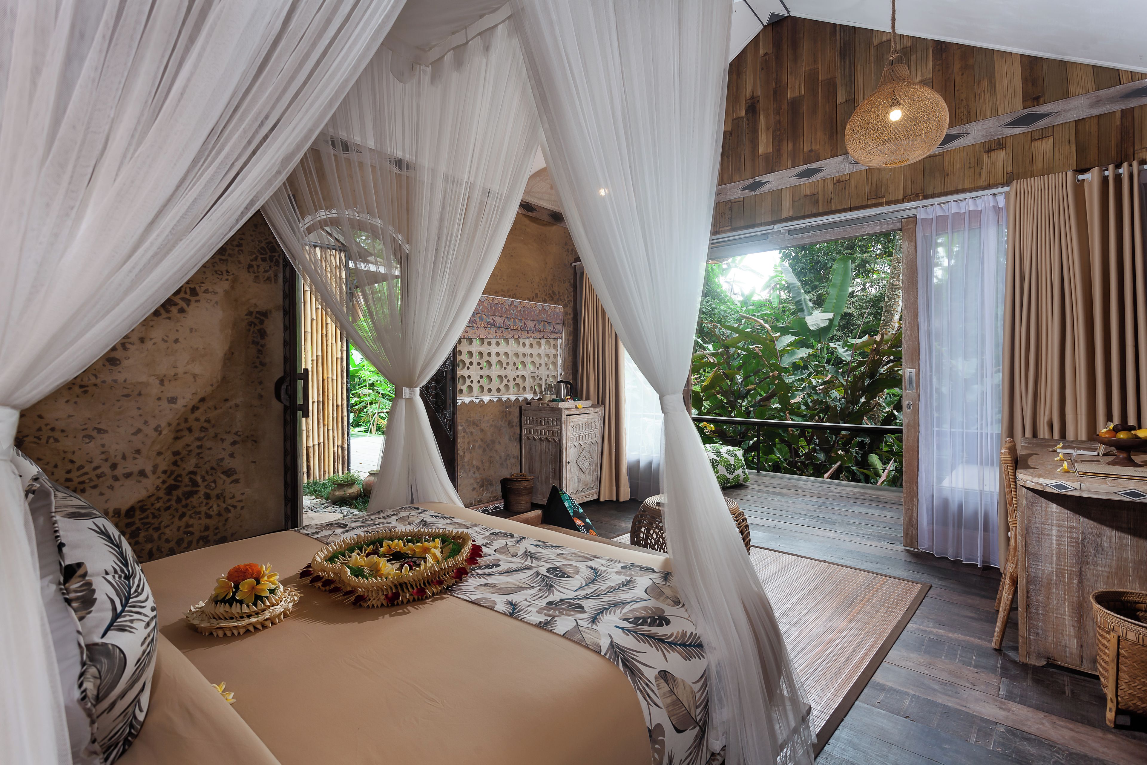 Un dormitorio con cama con dosel, una zona de comedor con mesa y sillas, y vistas al exterior.