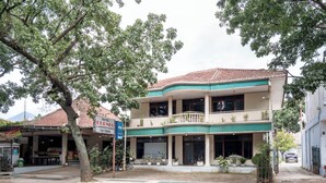 A two-story hotel with a balcony, large windows, and potted plants. - rehat at hotel kurnia karapitan (Bandung)
