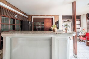 Una cocina con una isla grande, armarios de madera y un área de recepción con dispensador de agua.