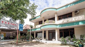 A hotel with a curved facade, multiple balconies, and potted plants. - rehat at hotel kurnia karapitan (Bandung)