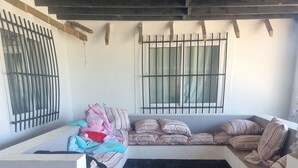 Une pièce avec un lit, un banc et une fenêtre avec des barreaux.