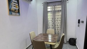 Une salle à manger moderne avec un sol à motifs de marbre, une table en bois et quatre chaises.