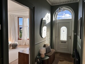 A hallway with a white door, a mirror, and a lamp on a side table. - Carmona Bank , Dunoon - sleeps 8 guests, dog friendly (DUNOON)