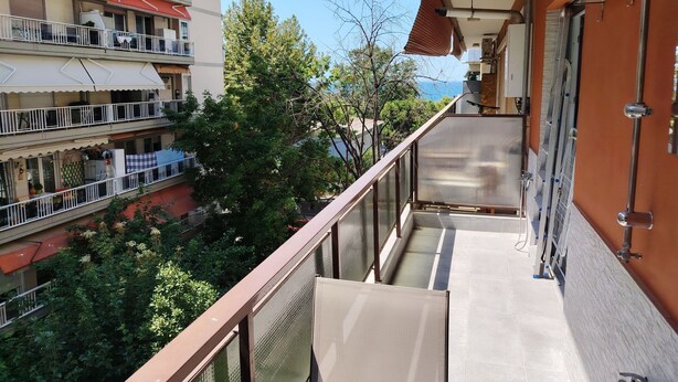 A balcony with a view of neighboring buildings and trees. - Waterfront Luxury Studio (Thessaloniki city)