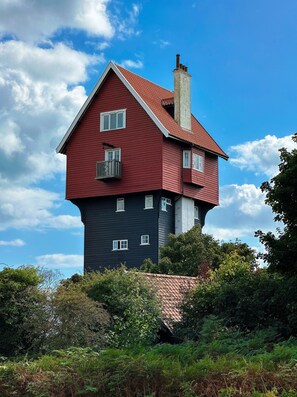 A two-story house with a red roof and a chimney, surrounded by dense greenery. - Deberri - sleeps 8 guests  in 4 bedrooms (Fressingfield)