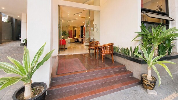 A hotel entrance with a glass door, a staircase leading inside, and potted plants. - Scarlet Hotel Stasiun Bandung (Bandung)
