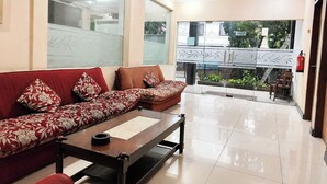 A modern lobby with a sofa set, a coffee table, and a fire extinguisher. - Scarlet Hotel Stasiun Bandung (Bandung)