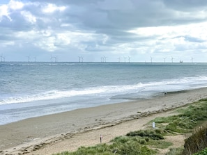 A beach with a view of wind turbines in the distance. - Hideaway near the sea - sleeps 6 guests & welcomes 2 dogs (Scratby)