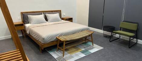 A bedroom with a bed, wooden bench, and a chair.