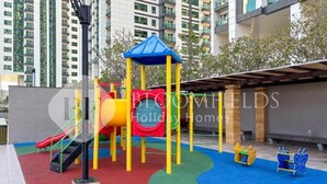 A playground with slides and climbing structures, surrounded by a building with balconies. - Bloomfields Iconic 1Br In Marina (Abu Dhabi)
