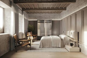 Un dormitorio con cama, mesita de noche, lámpara, silla y planta en maceta.