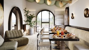 A dining area with a long table, chairs, and a sofa. There are various food items and drinks on the table. - Chapter Chianti (Cavriglia)