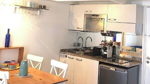 Eine kompakte Küche mit Essbereich, einem eingebauten Ofen und einem Kühlschrank.