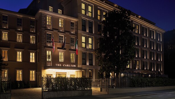 A multi-story hotel with a prominent entrance labeled 'THE CARLTON,' multiple windows, and flags. - The Carlton  (Milan)
