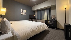 A hotel room with a large bed, a desk with a chair, a flat-screen TV, and a ceiling light. - Hotel Route Inn Grand Maebashi (Maebashi)