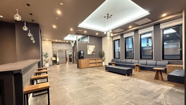 A modern lobby with a reception desk, seating area, and large windows. - Hotel Route Inn Grand Maebashi (Maebashi)