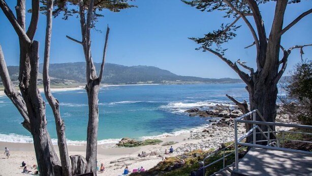 Una playa con terreno rocoso y una vista despejada del océano.